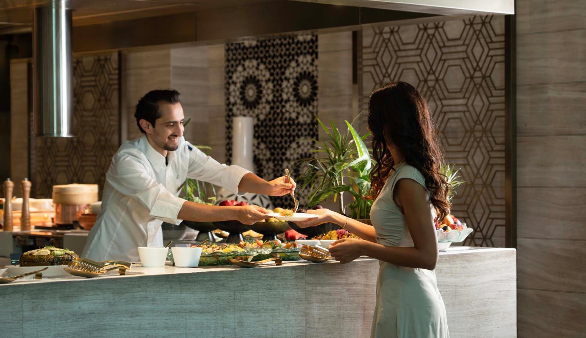 Fairmont Riyadh Exterior photo A chef serving a guest at the buffet